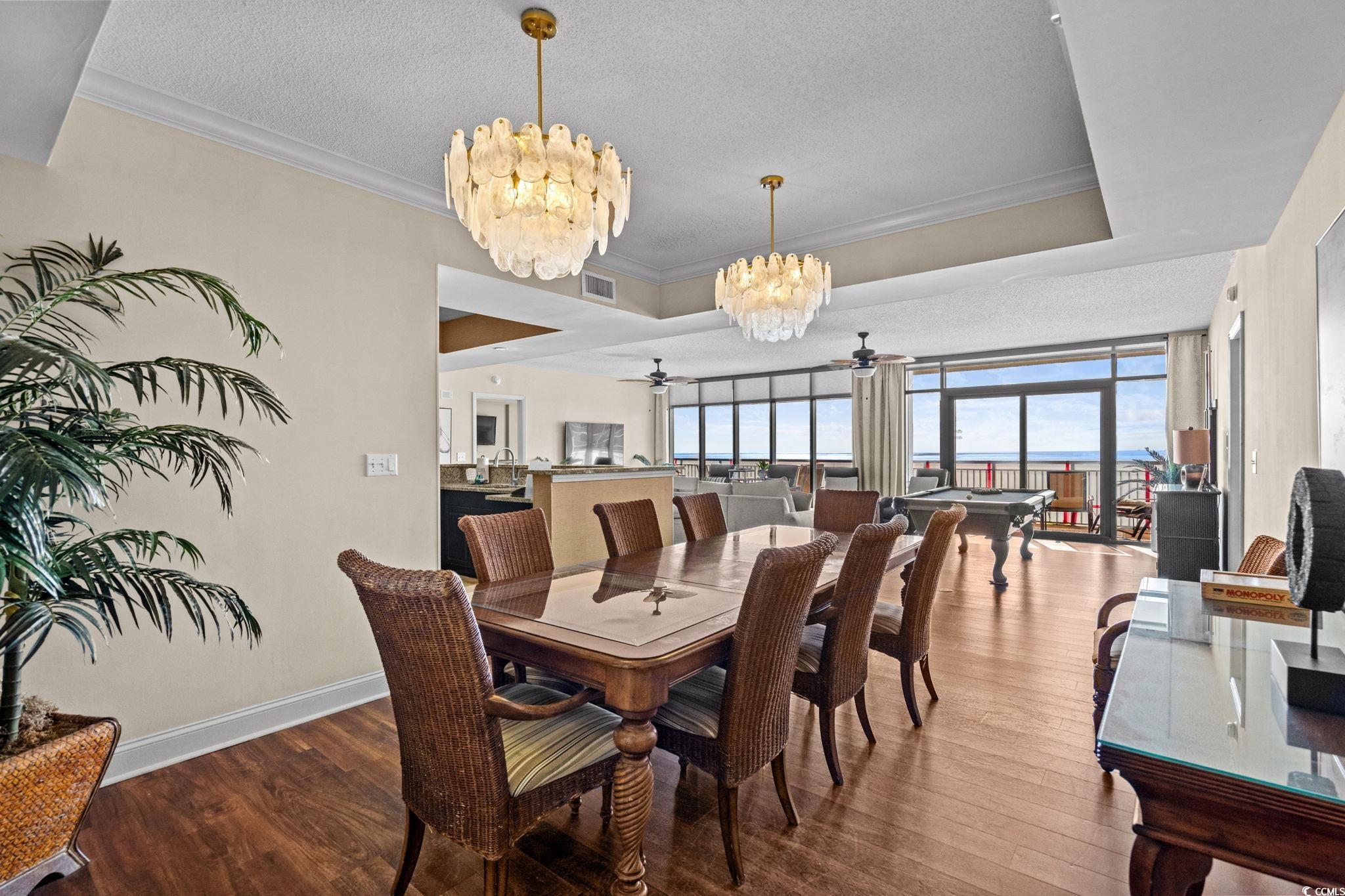 100 North Beach Boulevard, Unit 1803 North Myrtle Beach, SC 29582 - Photo 16 of 35 Dining space with crown molding, dark wood-type flooring, a textured ceiling, a chandelier, and a raised ceiling