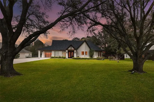a front view of a house with a garden and trees
