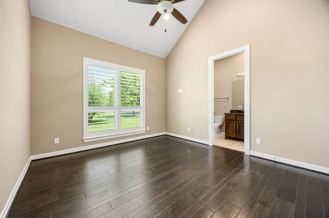 an empty room with wooden floor and a window