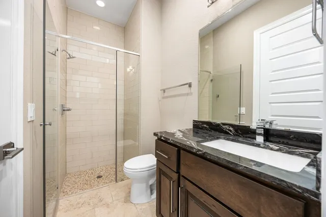 a bathroom with a granite countertop sink toilet and shower
