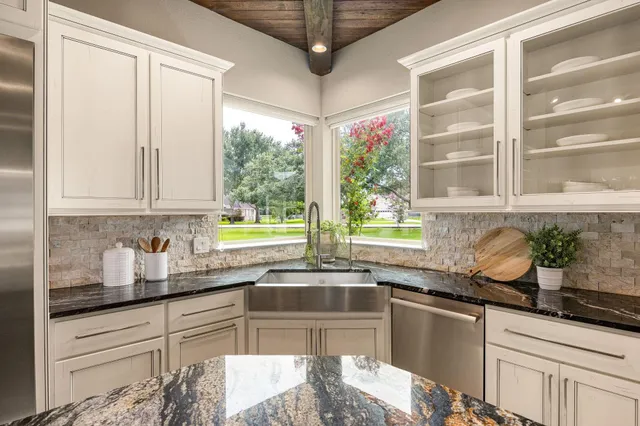 a kitchen with stainless steel appliances granite countertop a sink and a window