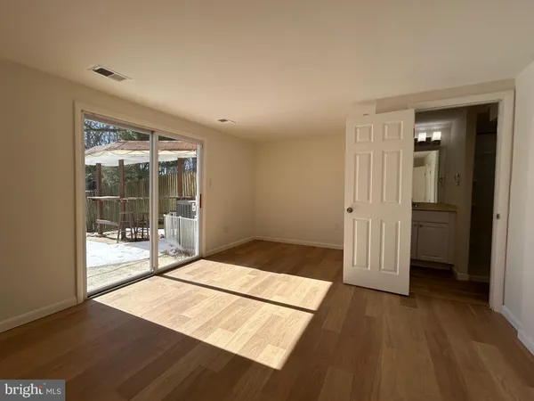 a view of a hallway with wooden floor and cabinet