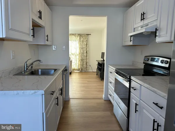 a kitchen with stainless steel appliances a sink dishwasher stove refrigerator and cabinets