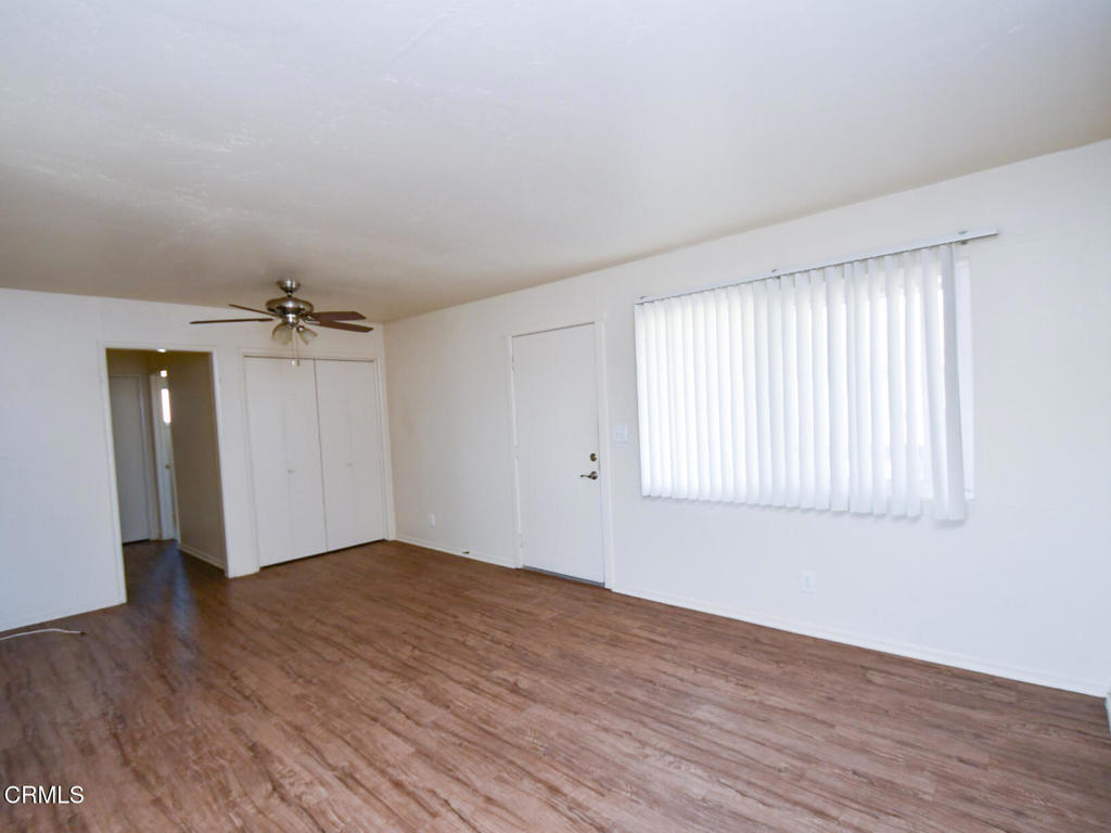 5009 Nautilus Street, Unit 14 Oxnard, CA 93035 - Photo 2 of 11 an empty room with wooden floor cabinet and windows