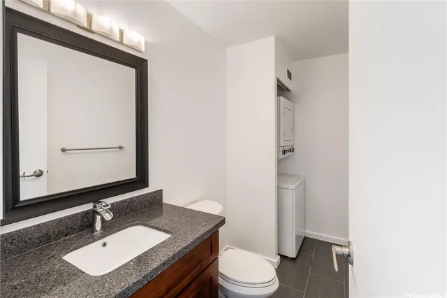 a bathroom with a granite countertop sink toilet a mirror and shower