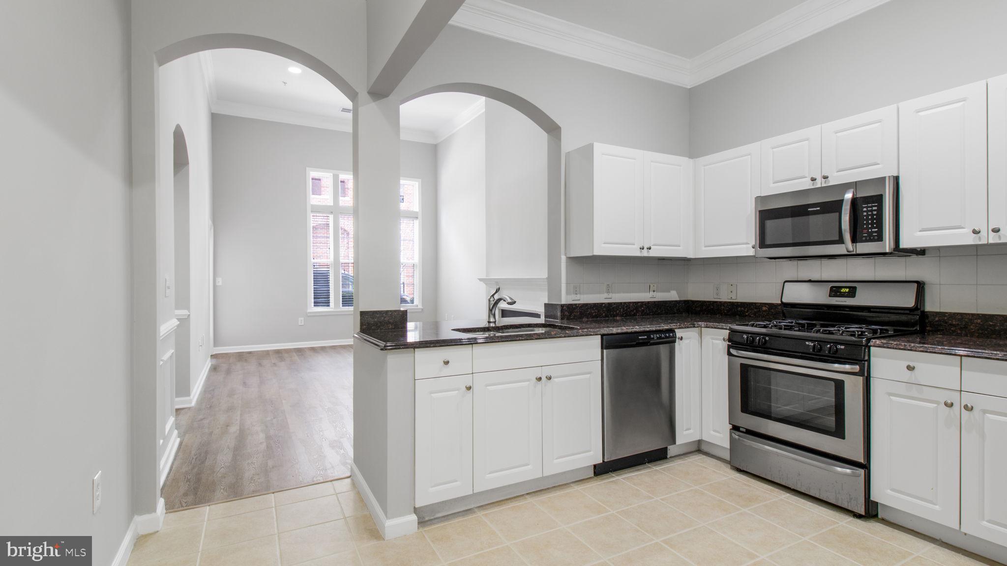 3 Arch Place, Unit 130 Gaithersburg, MD 20878 - Photo 11 of 45 a kitchen with stainless steel appliances granite countertop a stove a sink and a microwave