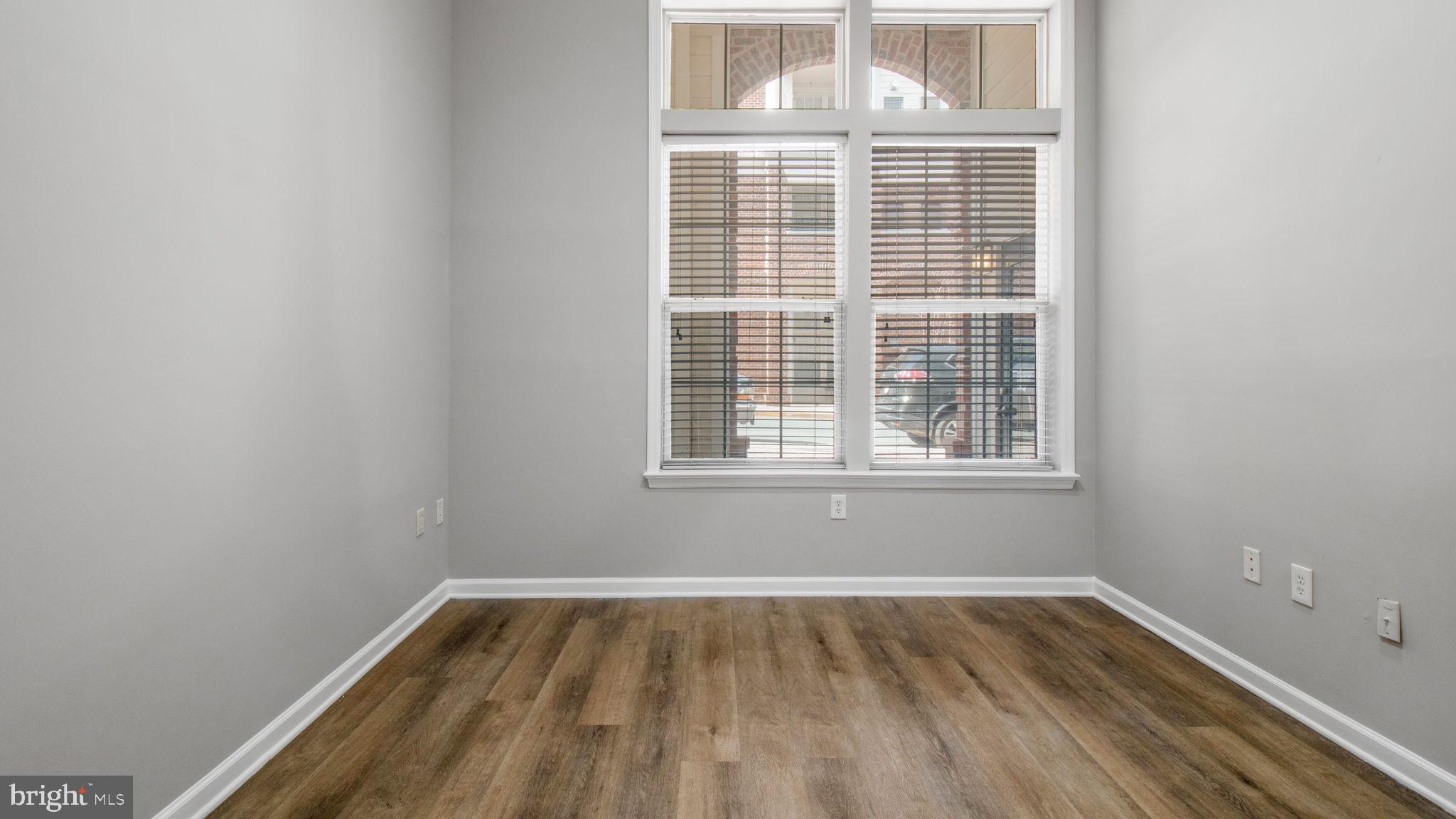 3 Arch Place, Unit 130 Gaithersburg, MD 20878 - Photo 18 of 45 a view of an empty room with wooden floor and a window