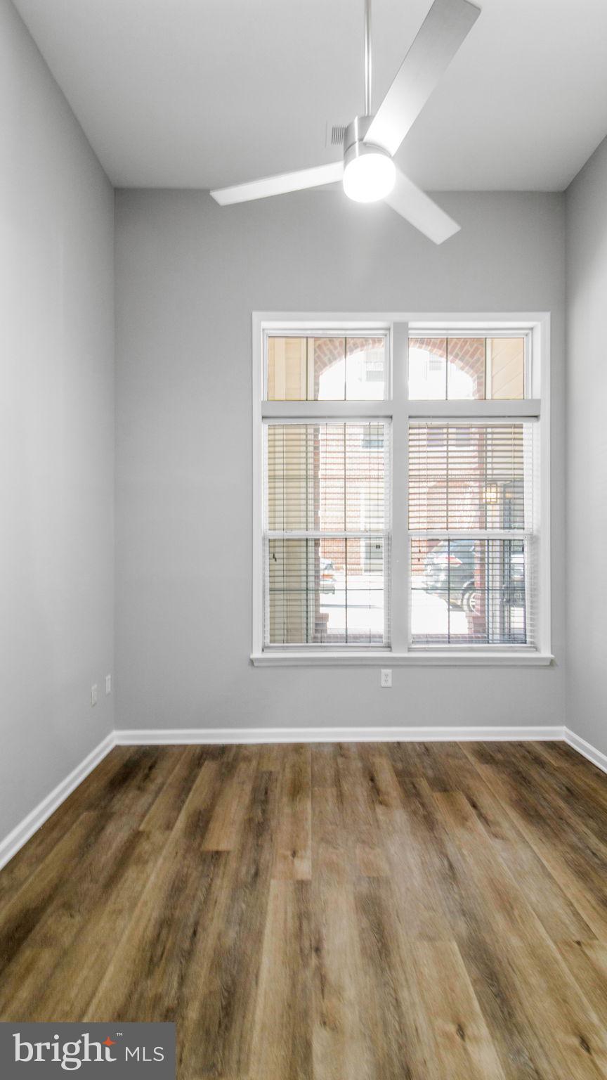 3 Arch Place, Unit 130 Gaithersburg, MD 20878 - Photo 19 of 45 an empty room with wooden floor and windows
