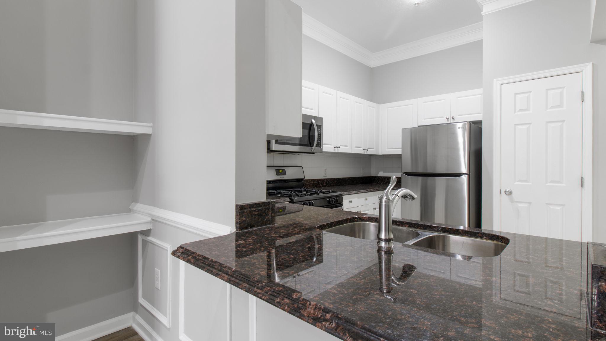3 Arch Place, Unit 130 Gaithersburg, MD 20878 - Photo 8 of 45 a kitchen with granite countertop a refrigerator and a sink