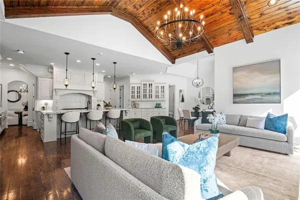 a dining room with furniture a chandelier and wooden floor