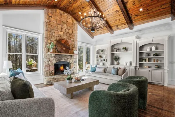 a dining room with furniture a kitchen a chandelier and wooden floor