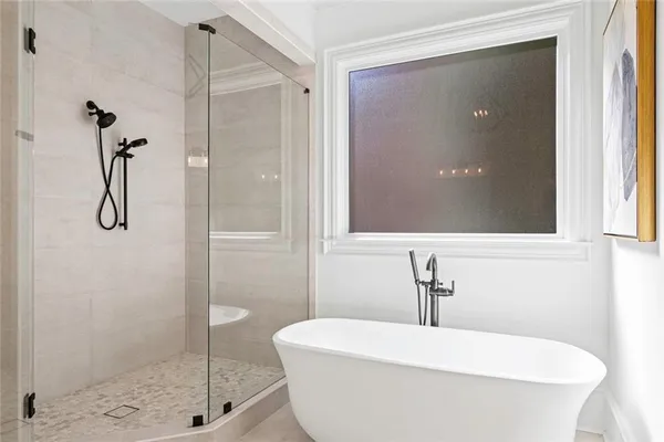 a bathroom with a granite countertop bathtub shower sink vanity mirror and toilet