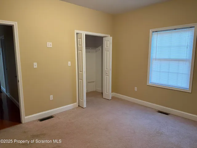 an empty room with windows and closet