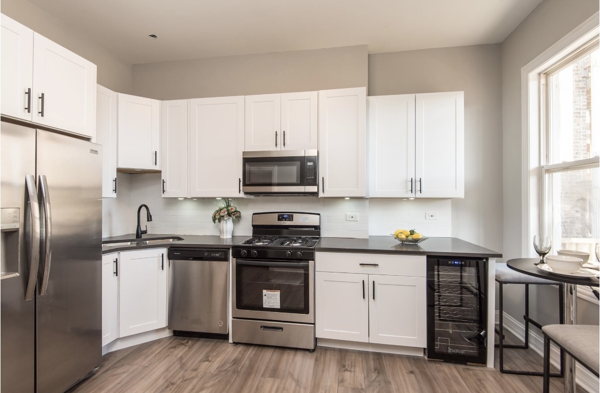 6607 South Ingleside Avenue Chicago, IL 60637 - Photo 16 of 28 a kitchen with stainless steel appliances granite countertop a stove a sink and a refrigerator