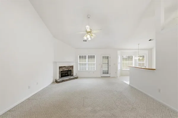 an empty room with a fireplace and windows