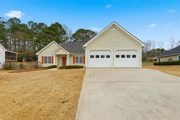 a view of house with yard and car parked