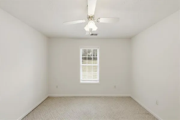 an empty room with a chandelier fan