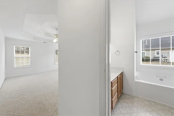 an empty room with windows and fan