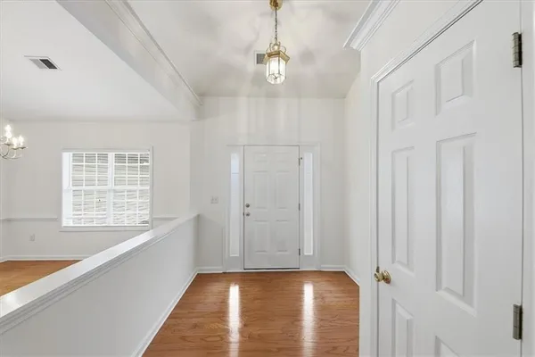 a view of a big room with wooden floor and windows