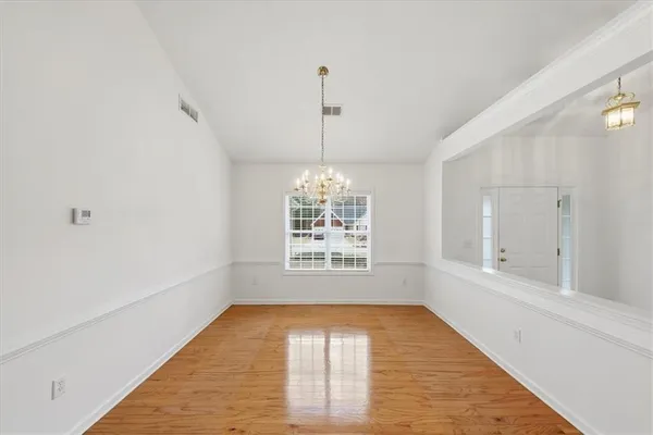 a view of a room with wooden floor and chandelier