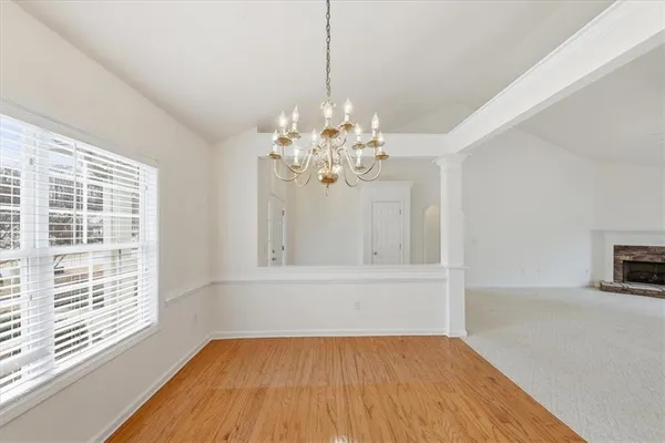 a view of a hallway with chandelier and wooden floor