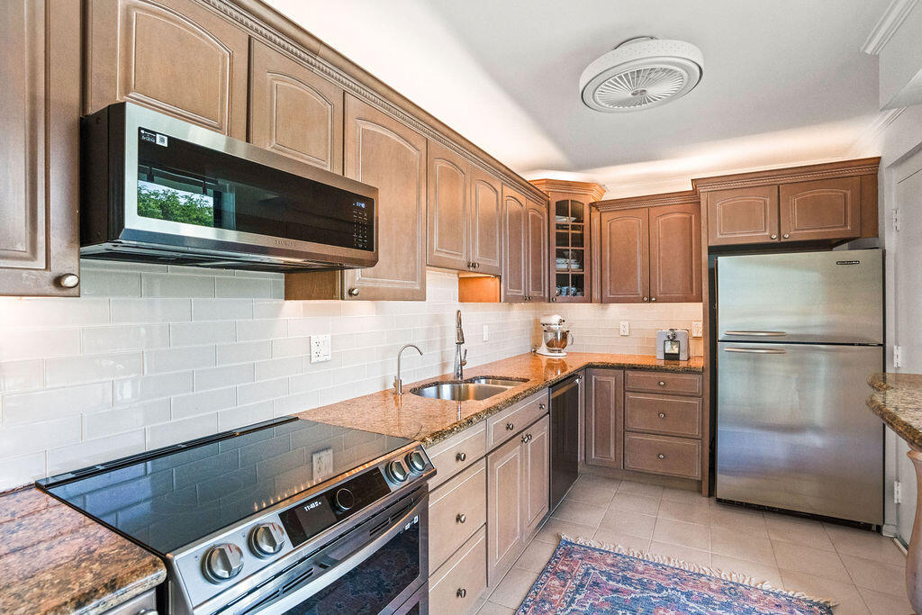 a kitchen with stainless steel appliances a stove a sink and a microwave