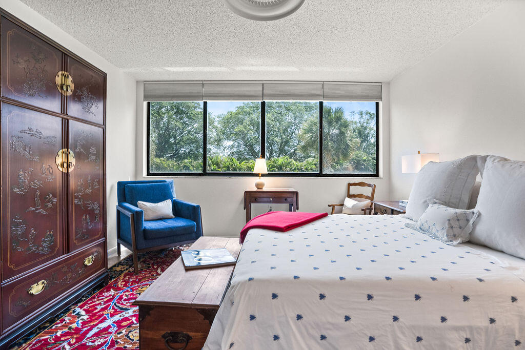 2520 Presidential Way, Unit 203 West Palm Beach, FL 33401 - Photo 12 of 27 a bedroom with a bed couch and window