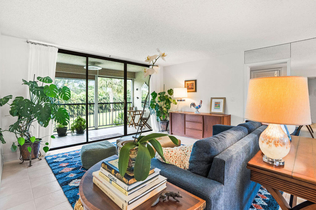 2520 Presidential Way, Unit 203 West Palm Beach, FL 33401 - Photo 2 of 27 a living room with furniture and a large window
