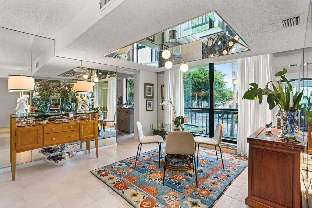 2520 Presidential Way, Unit 203 West Palm Beach, FL 33401 - Photo 21 of 27 a living room with furniture a rug and a large window