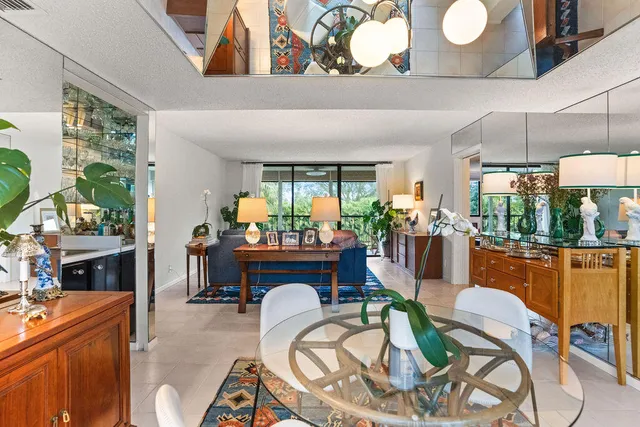 a living room with furniture a flat screen tv and a floor to ceiling window