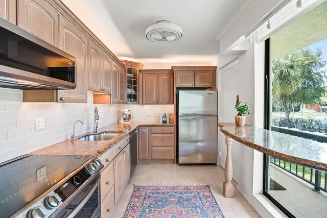 a kitchen with stainless steel appliances a sink and a refrigerator