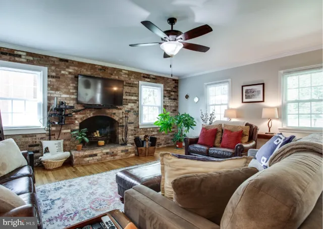 a living room with furniture a fireplace and a large window
