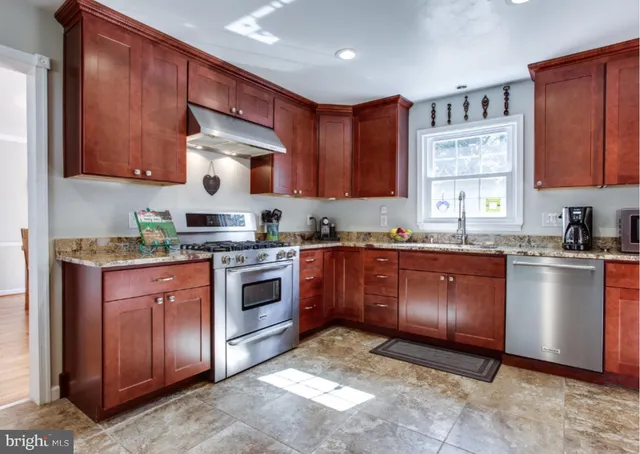 a kitchen with stainless steel appliances granite countertop a stove sink and cabinets
