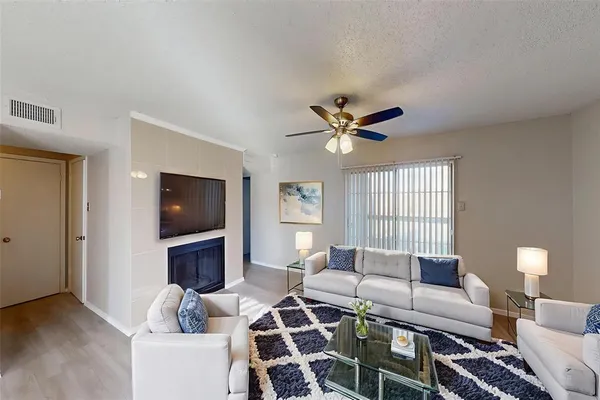 a living room with furniture a flat screen tv and a large window