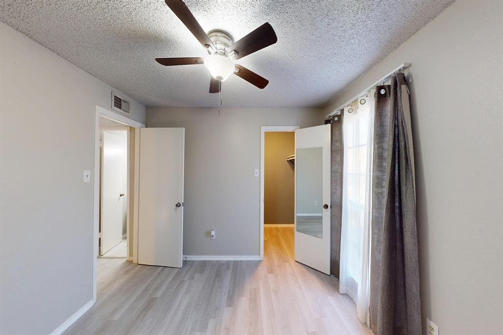 12484 Abrams Road, Unit 2121 Dallas, TX 75243 - Photo 19 of 27 an empty room with wooden floor and a large window