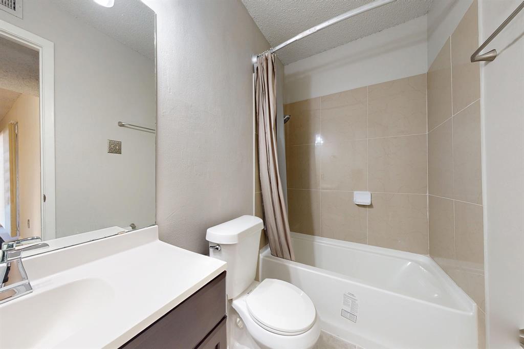 12484 Abrams Road, Unit 2121 Dallas, TX 75243 - Photo 21 of 27 a white toilet sitting next to a bathroom sink and tub