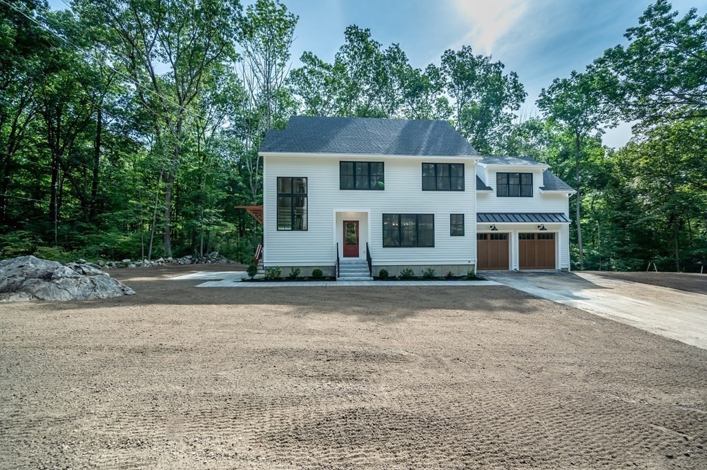 5 Tucker Road Andover, MA 01810 - Photo 3 of 42 a front view of a house with a yard and garage