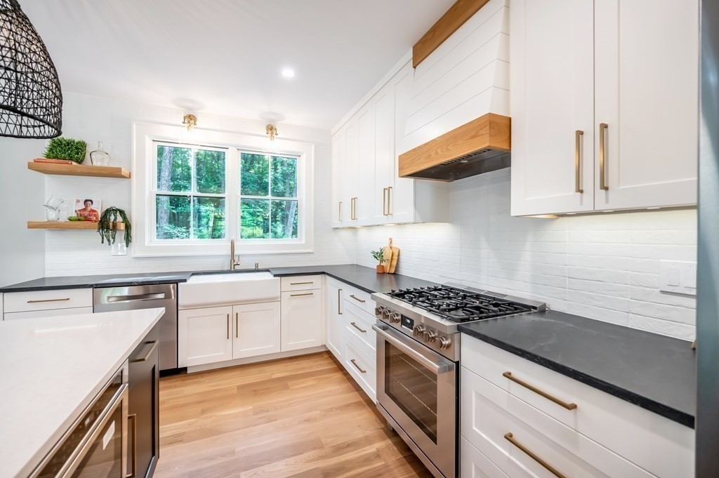 5 Tucker Road Andover, MA 01810 - Photo 7 of 42 a kitchen with stainless steel appliances a sink dishwasher stove and white cabinets with wooden floor