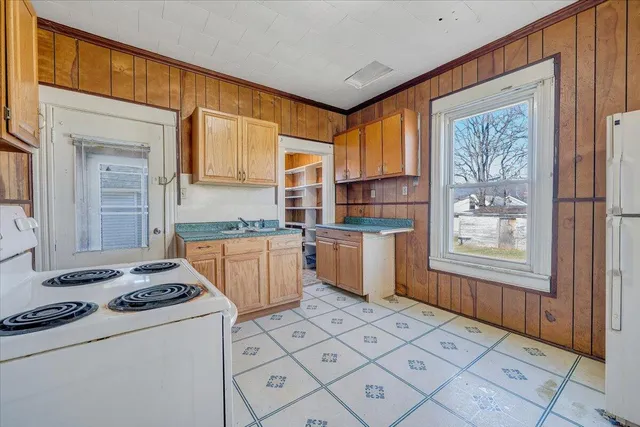 a kitchen that has a sink cabinets and a stove top oven