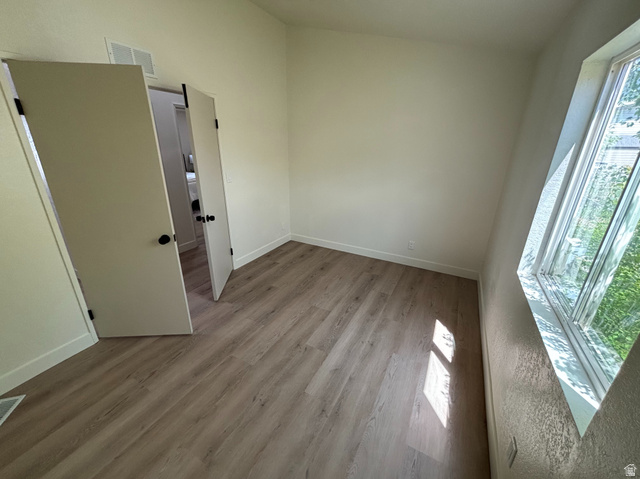 11313 South 265 East Sandy, UT 84070 - Photo 13 of 21 Room featuring wood-finish flooring, white walls, and a large window