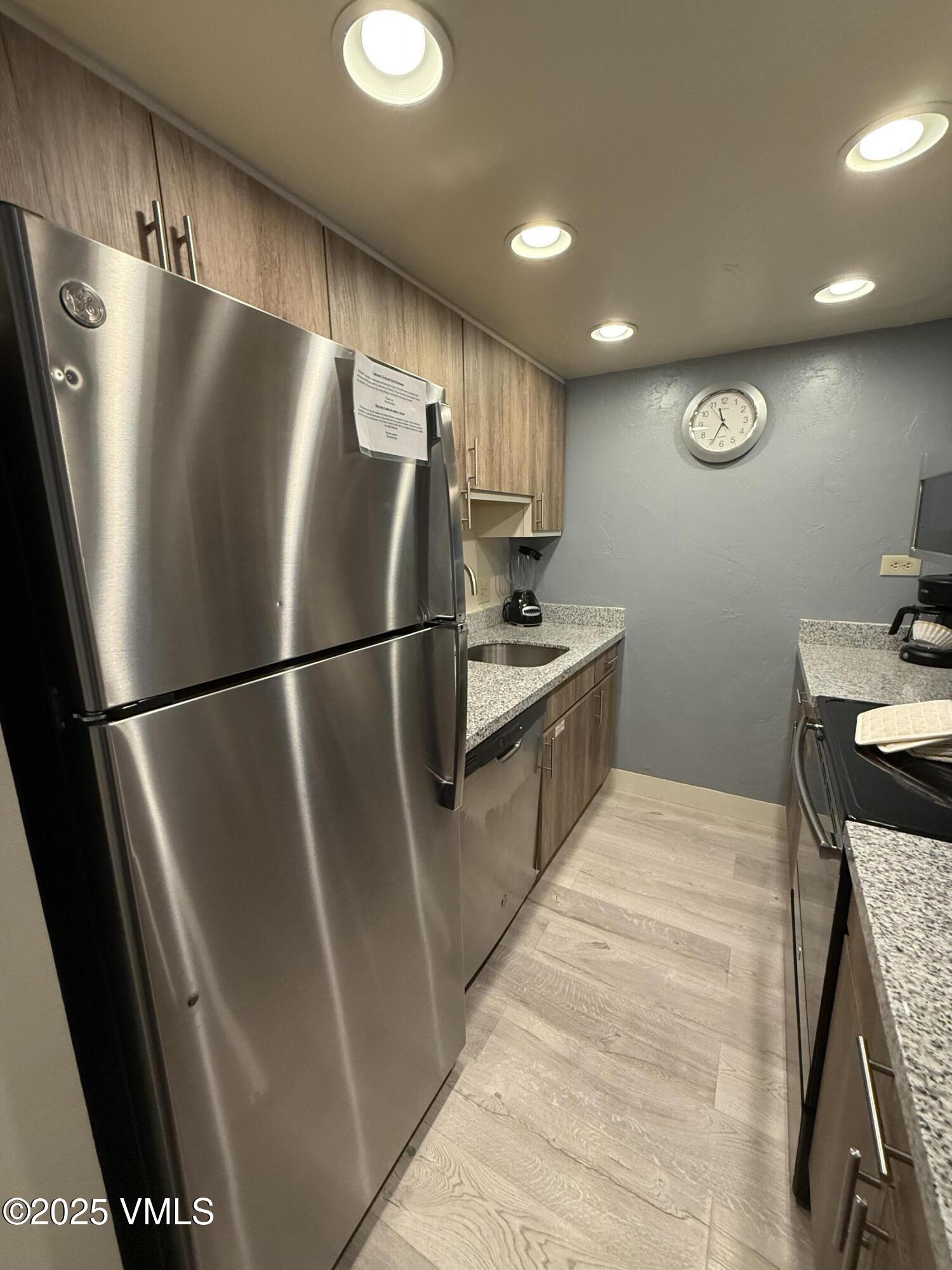 a kitchen with stainless steel appliances granite countertop a refrigerator a sink and a stove