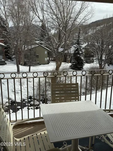 a view of a brick house with large trees and wooden fence