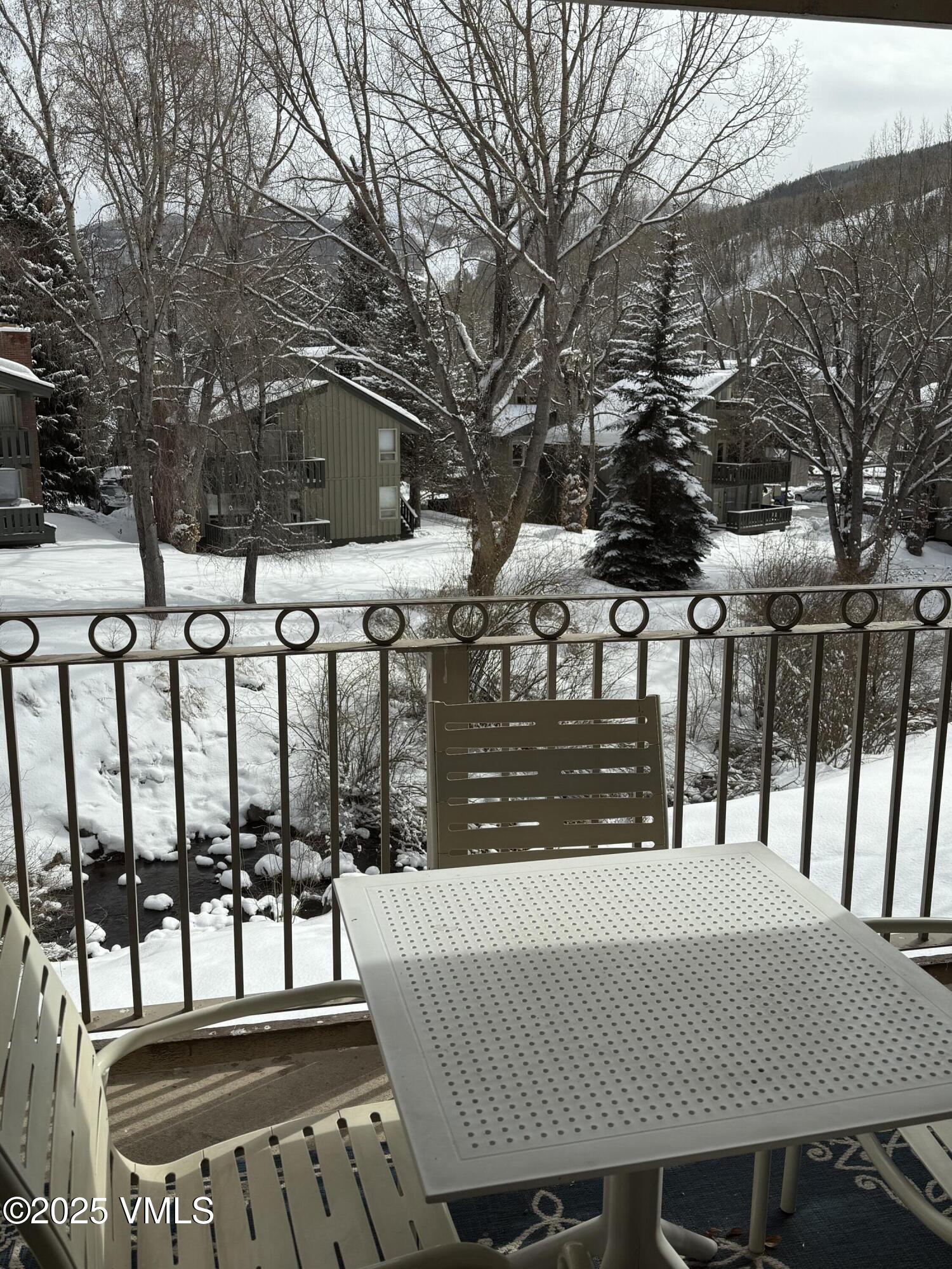 1020 Vail View Drive, Unit 130849 Vail, CO 81657 - Photo 4 of 20 a view of a brick house with large trees and wooden fence