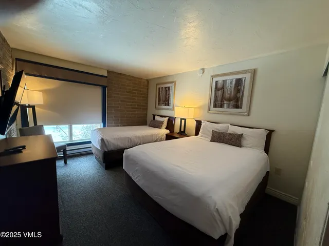 a bedroom with two beds and a window