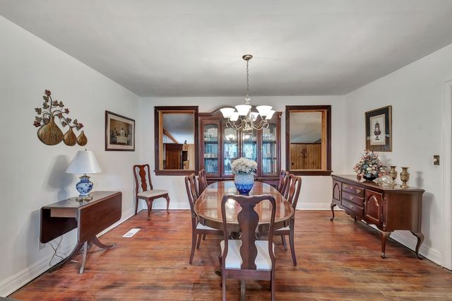 a view of a dining room with furniture wooden floor and chandelier