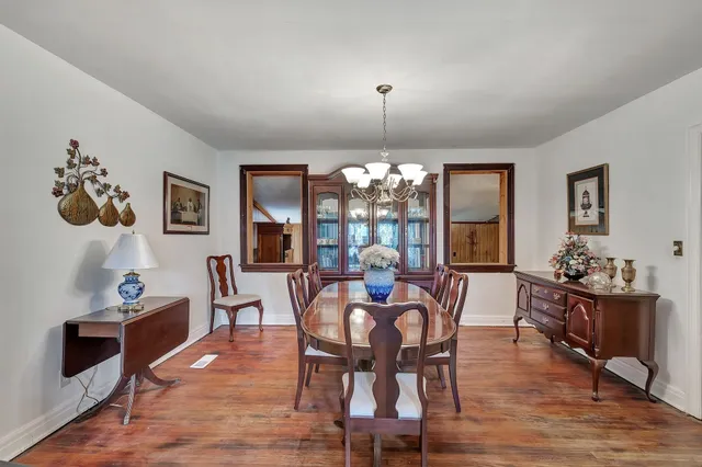 a view of a dining room with furniture wooden floor and chandelier