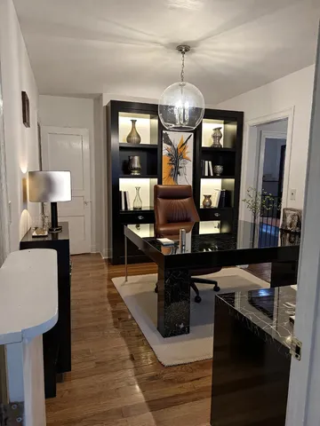 a view of a dining room with furniture a chandelier and wooden floor
