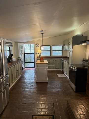 a large kitchen with stainless steel appliances kitchen island granite countertop a table and chairs