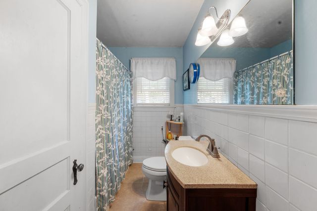 a bathroom with a sink a toilet and a mirror