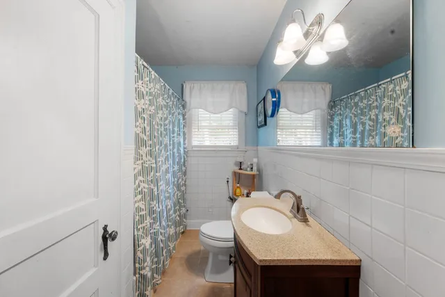 a bathroom with a sink a toilet and a mirror